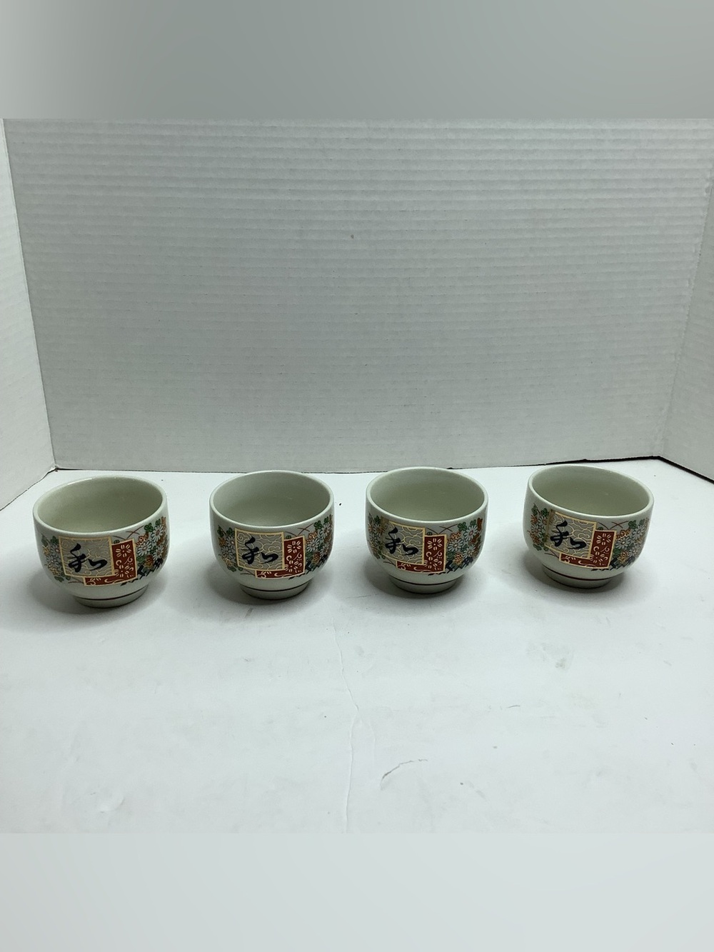 Set of Four White Porcelain Japanese-Style Tea Cups with Floral Motif